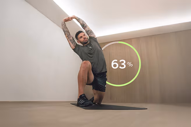 Man stretching in a cream themed studio with GOWOD Mobility score behind him