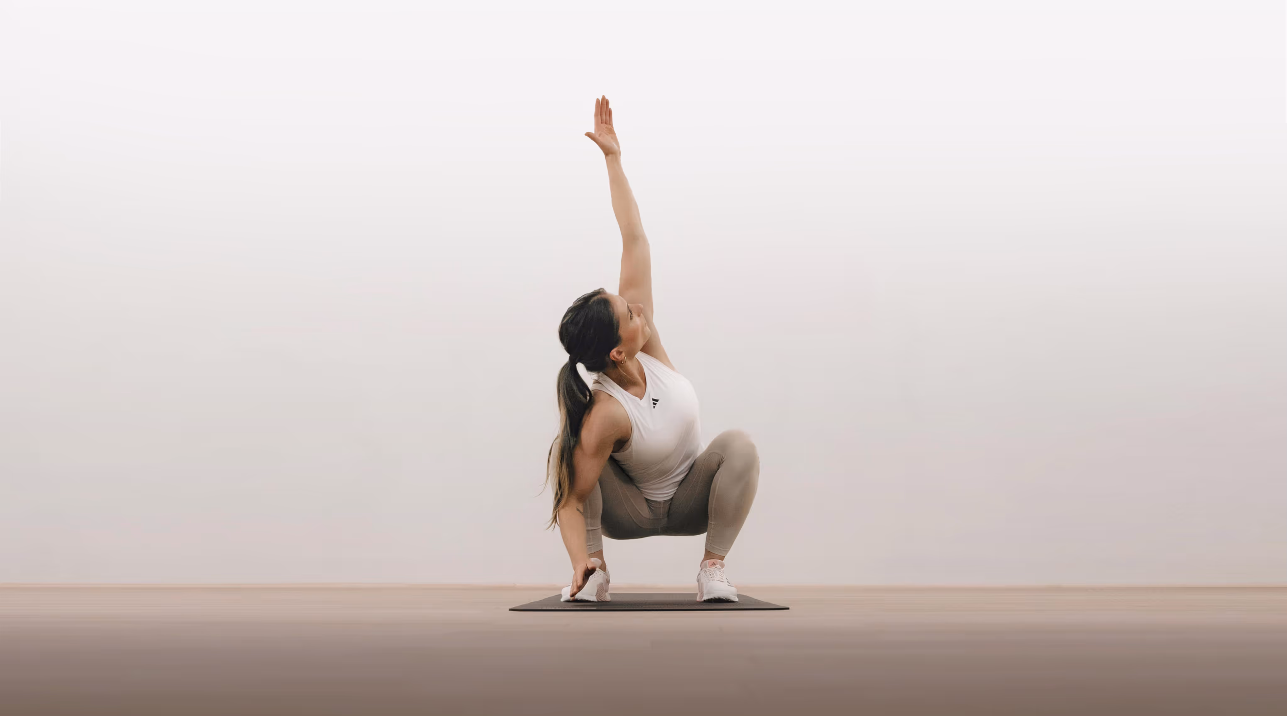 Woman performing GOWOD stretch in a light studio