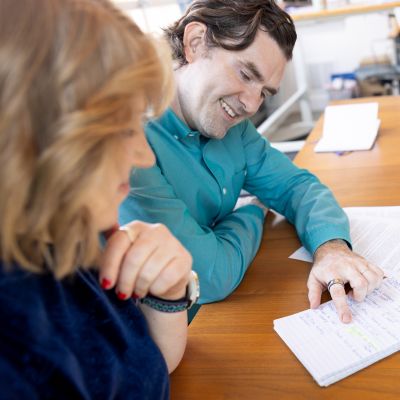 A happy man and a women reviewing documents in an office. 