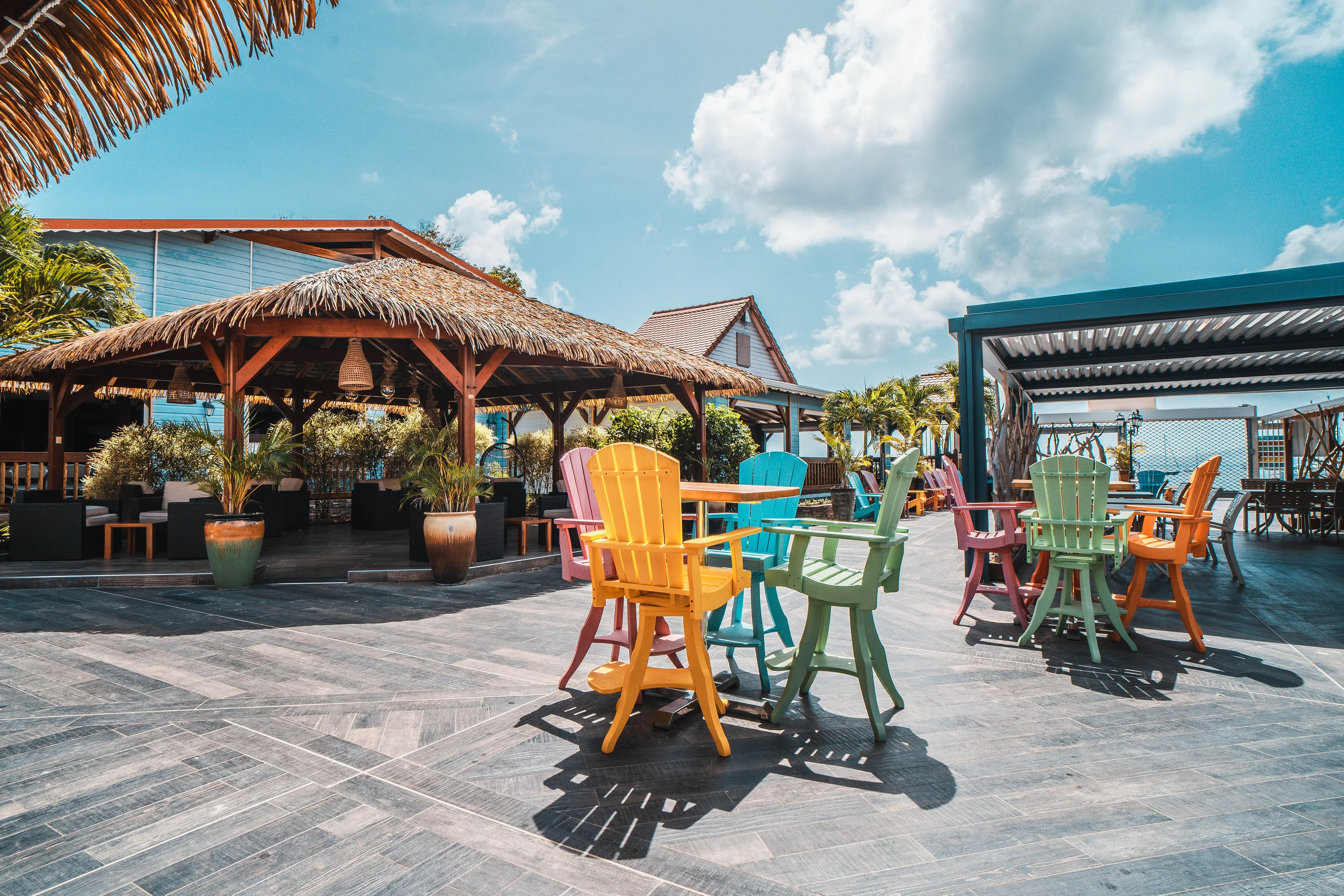 Seaside terrace Bambouresort colorful armchairs paillotes pool view Martinique