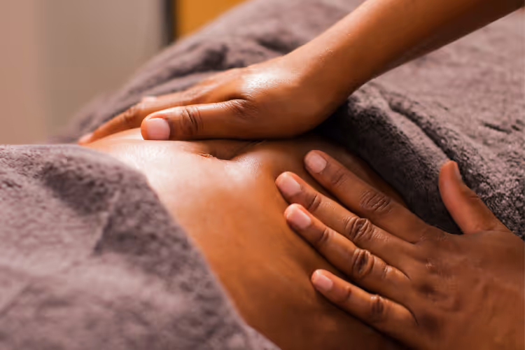 Hands giving therapeutic massage on back covered with grey towel