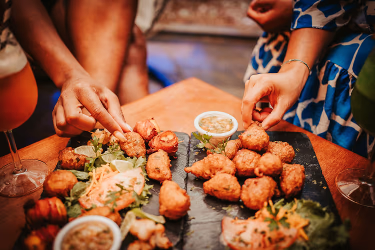 Bouchées de poulet frit servies sur ardoise avec sauces et garnitures fraîches