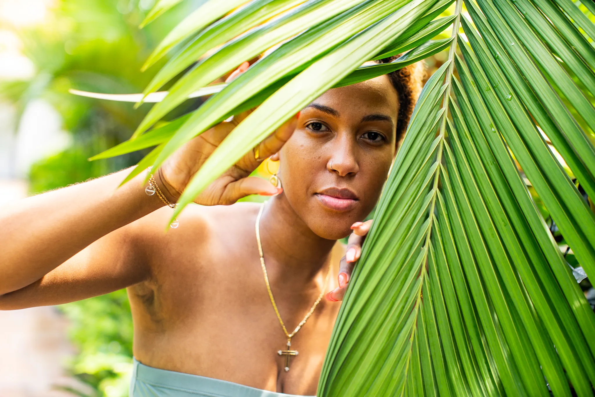 Portrait tropical encadré par feuille de palmier verte sous lumière naturelle