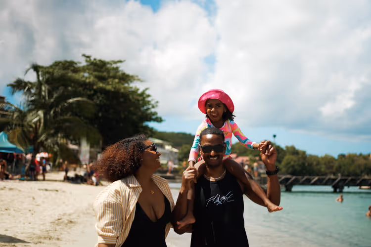 Famille profitant d'une journée ensoleillée sur plage tropicale bord de mer turquoise