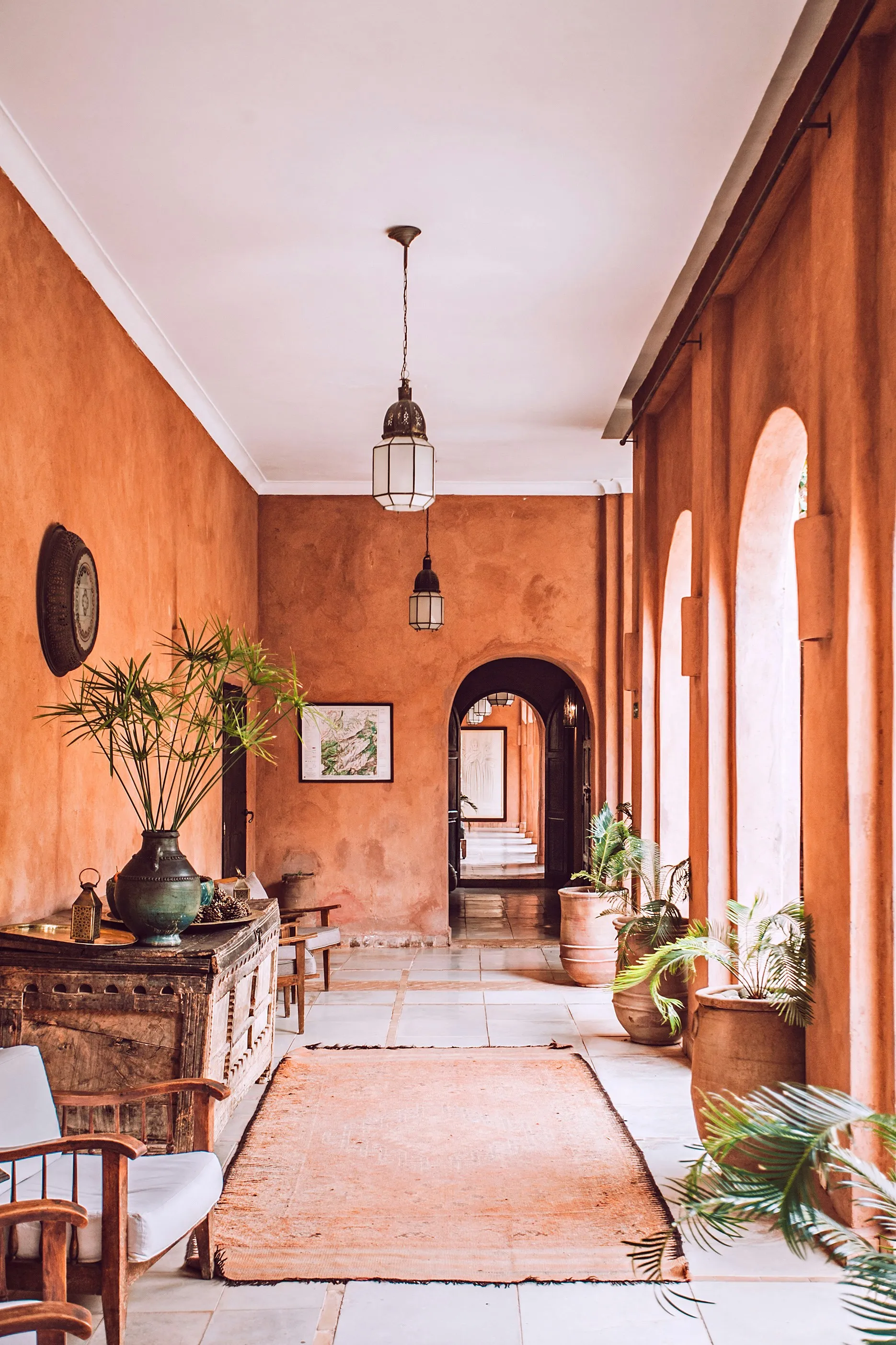 Couloir style marocain murs terracotta lampes suspendues plantes vertes tapis oriental