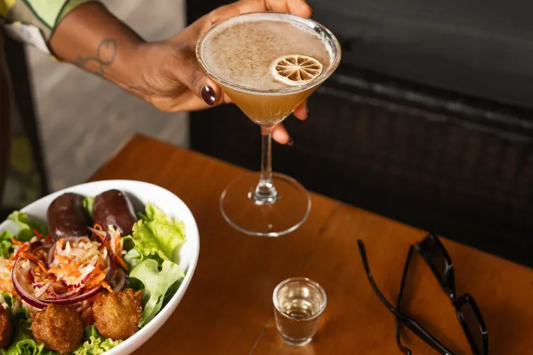 Cocktail agrume garni citron séché servi avec salade fraîche et bouchées croustillantes