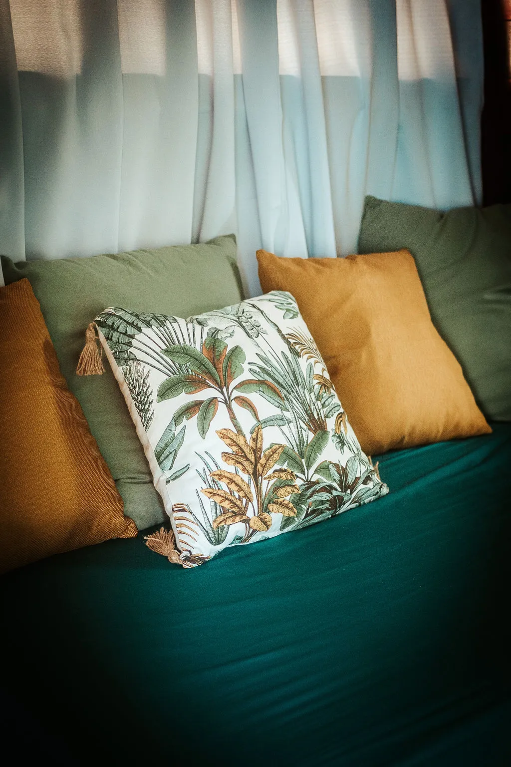 Tropical palm design cushions on emerald green sofa BambouResort Martinique