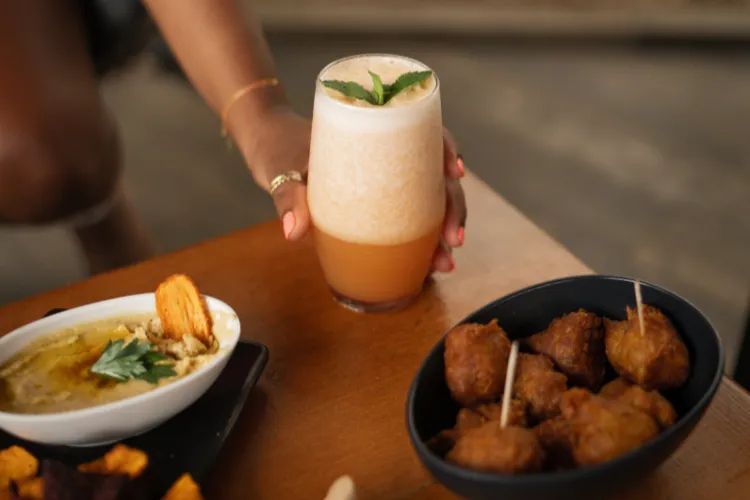 Signature sparkling cocktail garnished with fresh mint served with accras martiniquais Bambou Resort