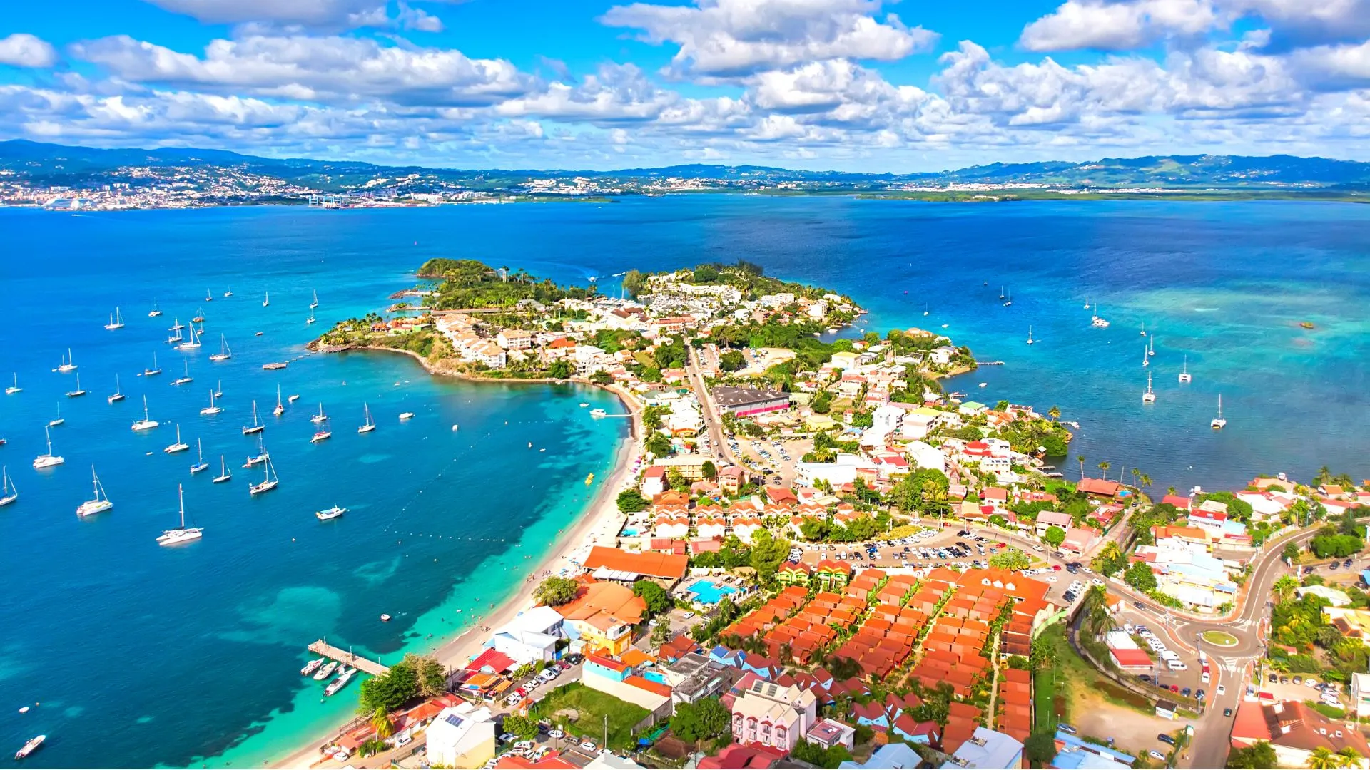 Aerial view of Trois-Ilets Martinique with boats anchored in turquoise bay and tropical beaches