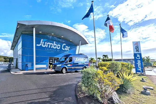 Jumbo Car rental agency modern facade flags Guadeloupe airport