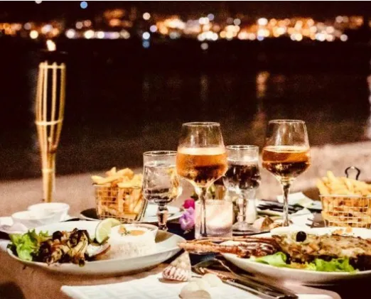 Romantic dinner at the water's edge refined dishes wine glasses bamboo torch Martinique