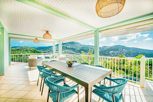 Panoramic terrace luxury villa Martinique mountain view table chairs turquoise bamboo