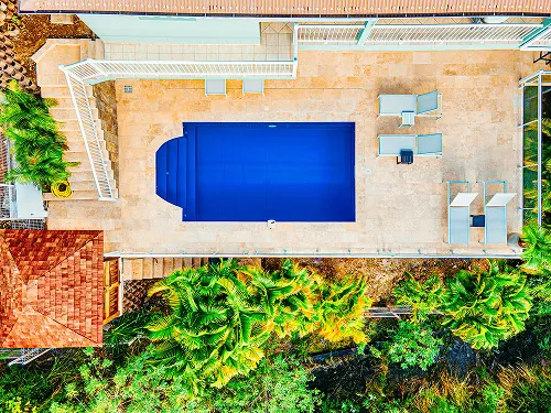 Aerial view of blue pool Villa Escapade Tropicale surrounded by lush gardens Martinique