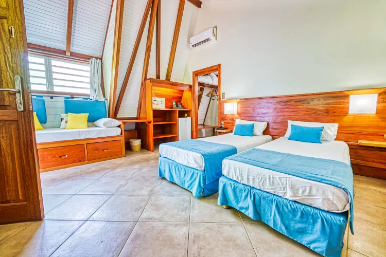Tropical bungalow two twin beds blue wooden walls built-in bench Bambou Resort Martinique
