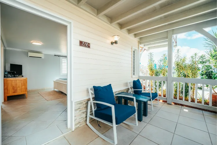 Private terrace luxury bungalow Bambou Resort blue armchairs sea view palm trees Martinique