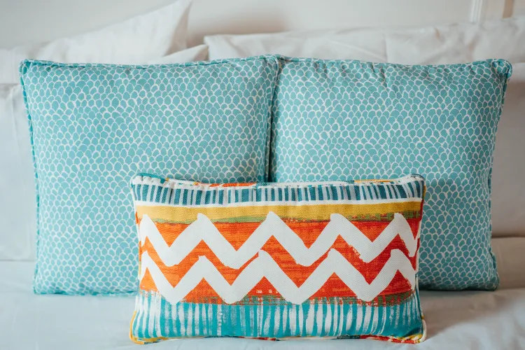 Decorative turquoise cushions with orange chevron pattern on luxury Martinique bungalow bed