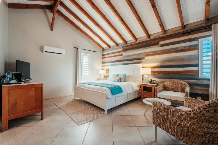 Luxury bungalow room Bamboo Resort exposed beams rattan armchairs sea view Martinique