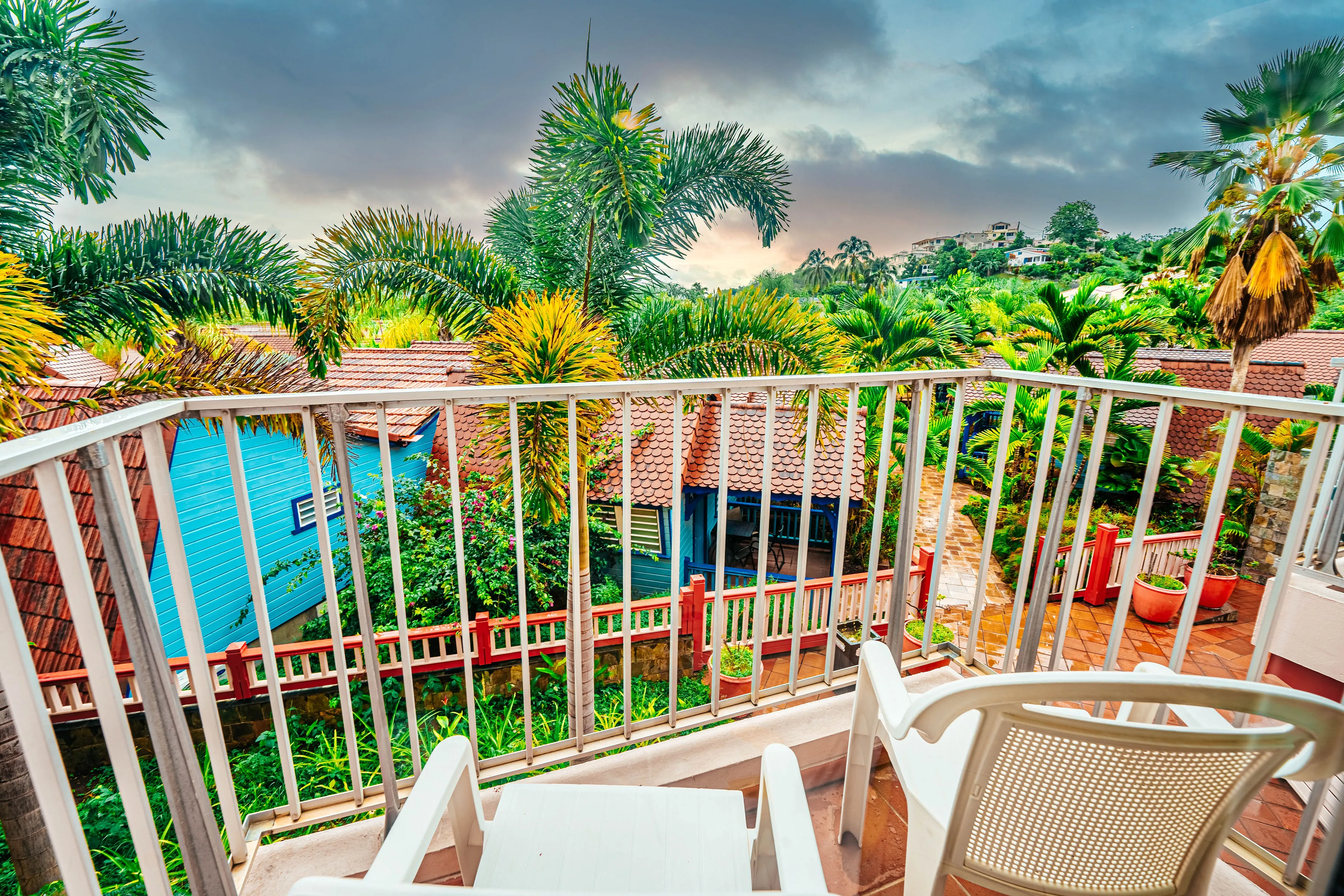 Private balcony pool view tropical palm trees Bambouresort Martinique sunset