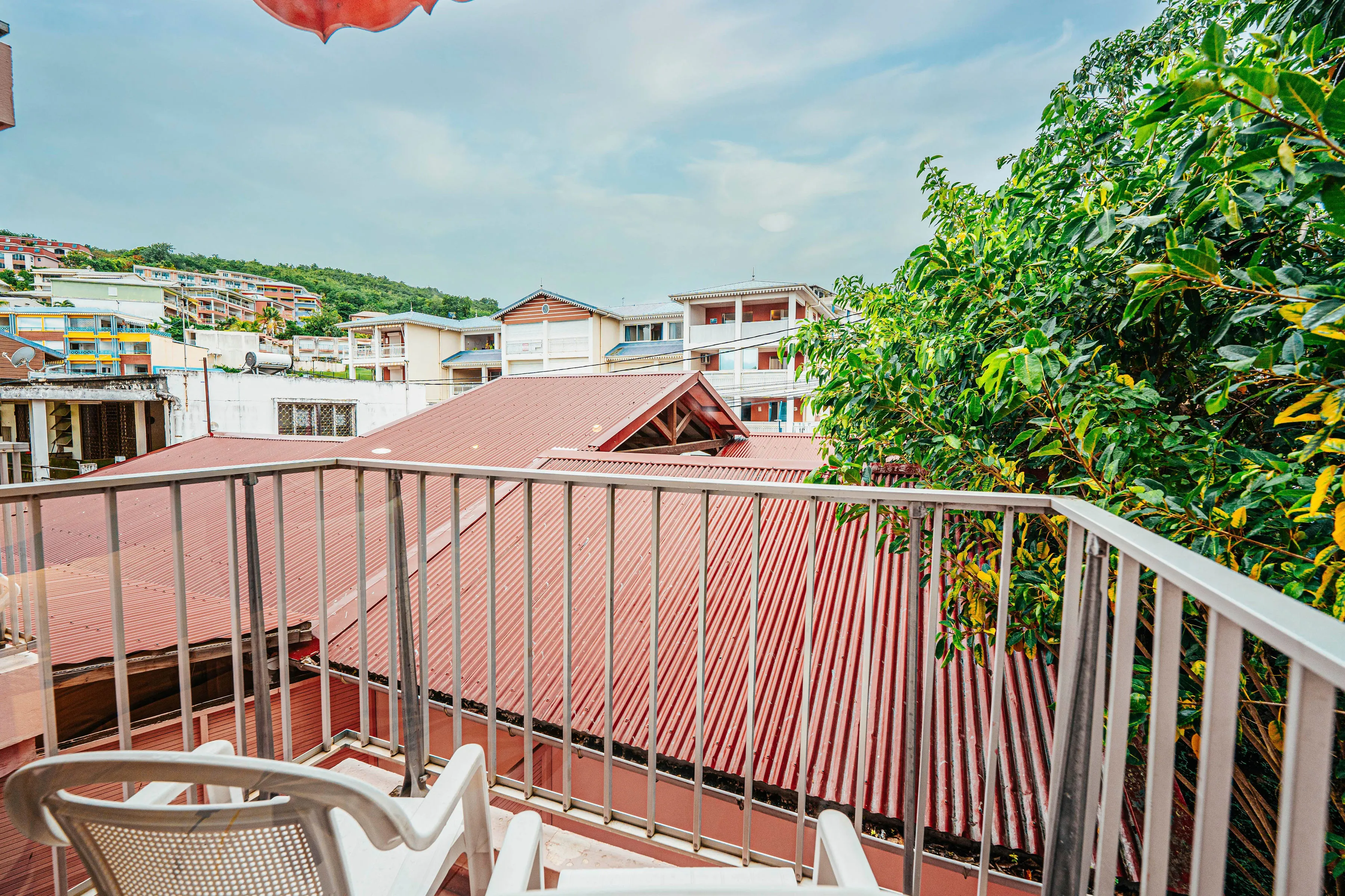 Private balcony Gran Kay room with view of Martinique rooftops and tropical lemon tree
