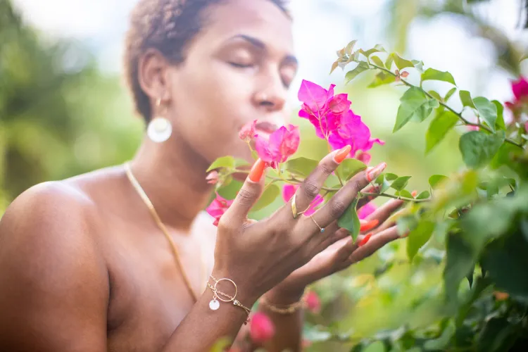 Delicate hands touching pink bougainvillea flowers in a tropical garden in Martinique