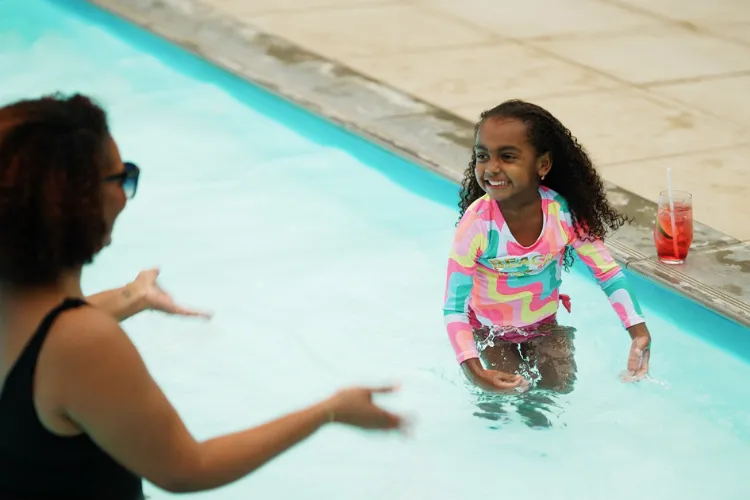 Children enjoying themselves in the turquoise pool at the Bambou Resort Martinique during swimming lessons.