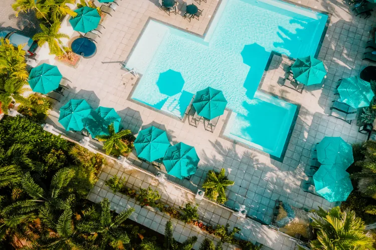 Luxury aerial view pool turquoise parasols palm trees Bambouresort Martinique