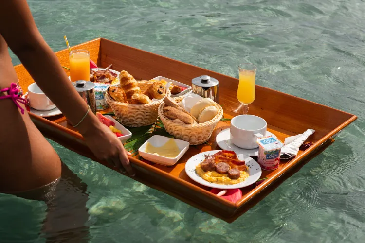 Tropical floating breakfast served on a wooden tray in the Bambou Resort Martinique swimming pool