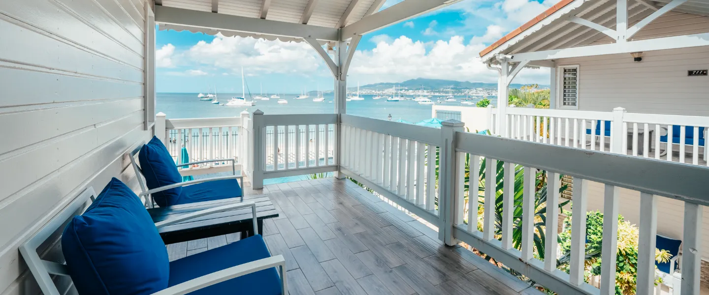 Covered terrace with blue deckchairs overlooking the bay and sea view of Martinique Bambouresort