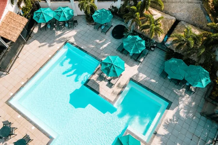Luxurious pool lined with turquoise parasols Bambouresort Martinique aerial view
