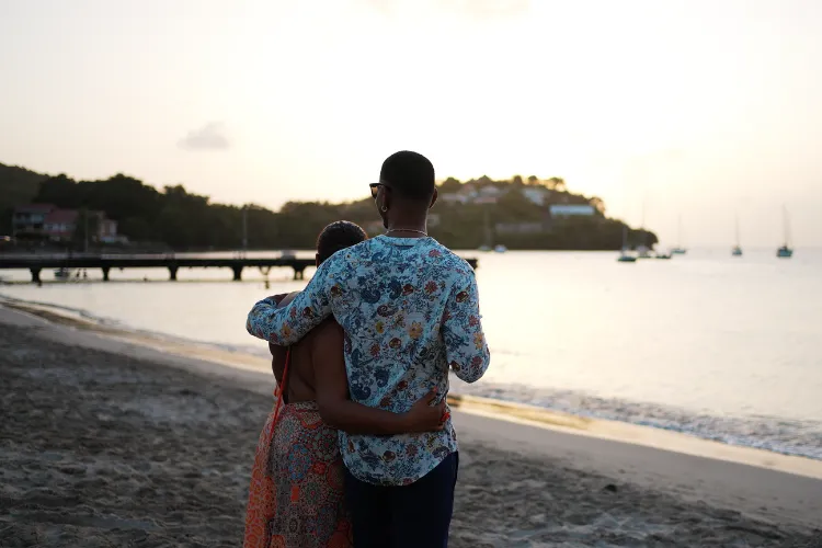 Embracing couple contemplating sunset on private beach Bambou Resort Martinique