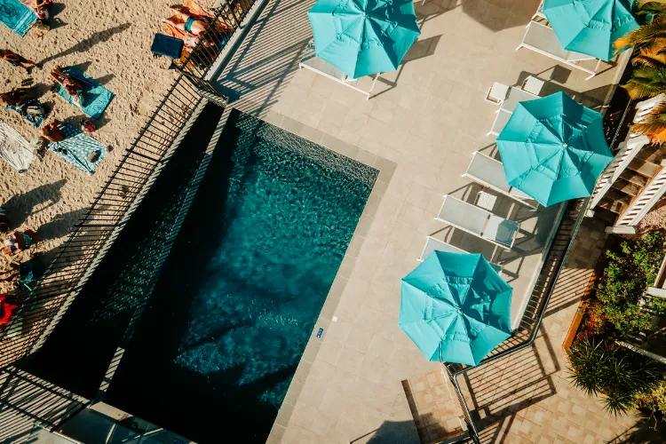Luxury pool lined with turquoise parasols aerial view Bamboo Resort Martinique