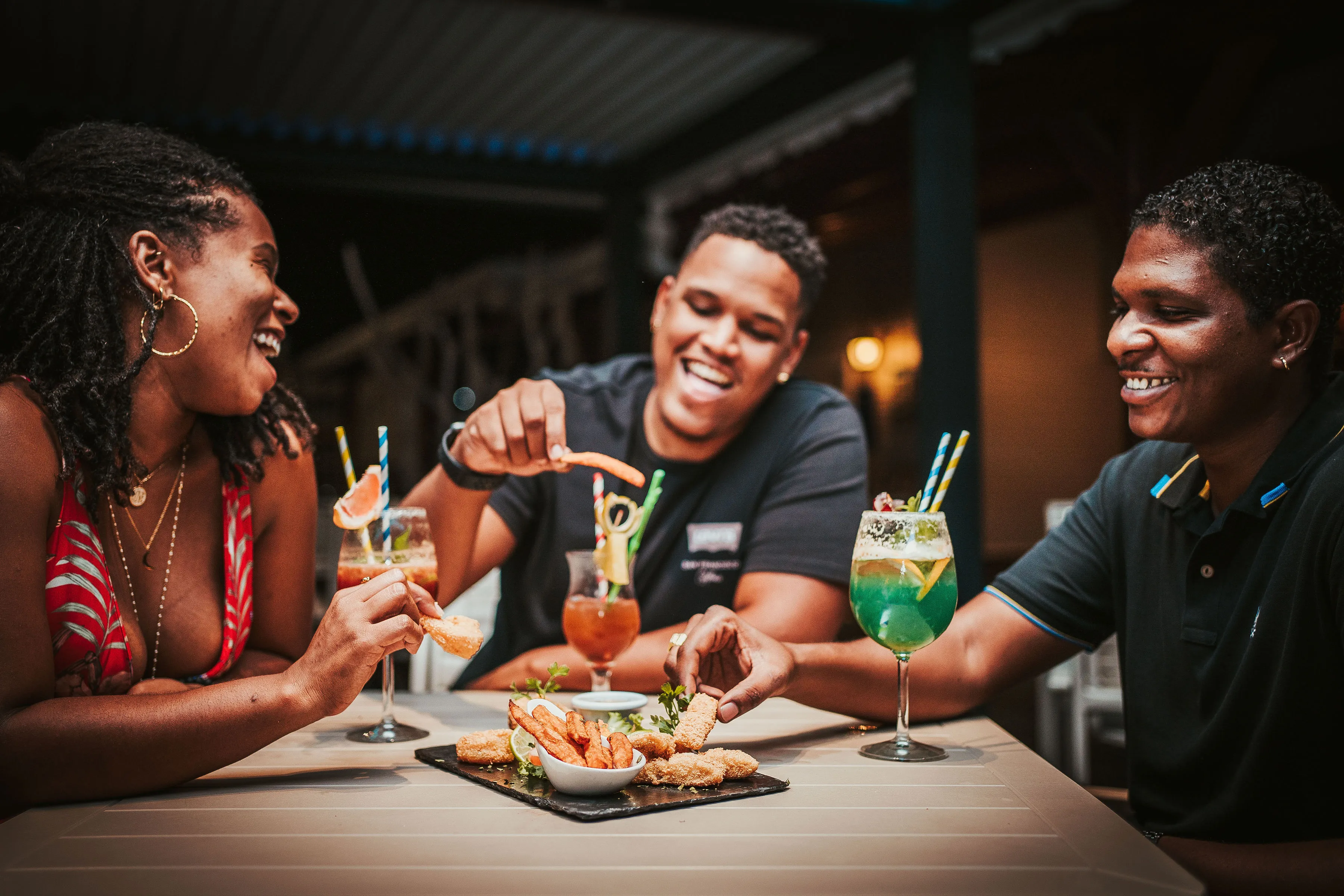 Guests sharing tropical cocktails and tapas at the BambouResort Martinique restaurant