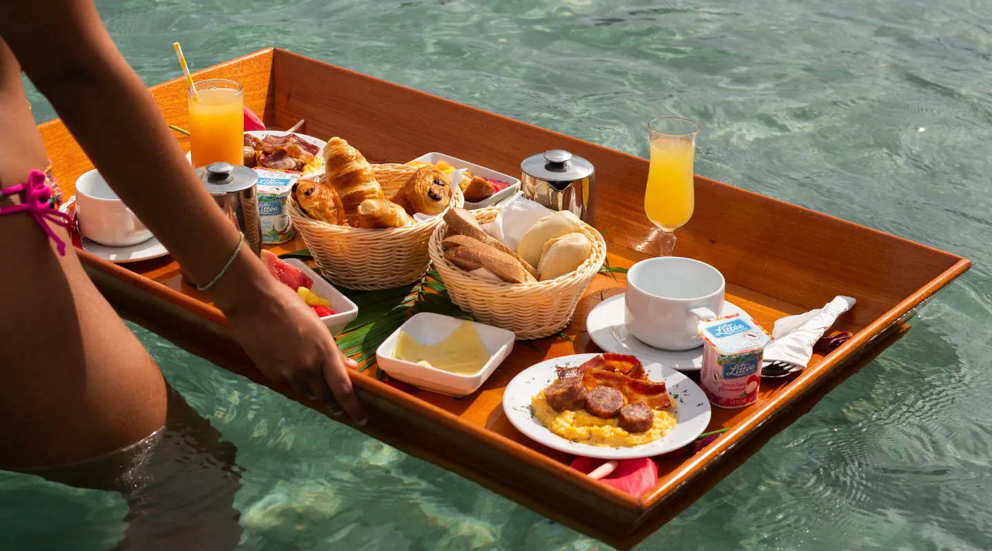 Floating breakfast served on a wooden tray in the luxury pool Bambouresort Martinique