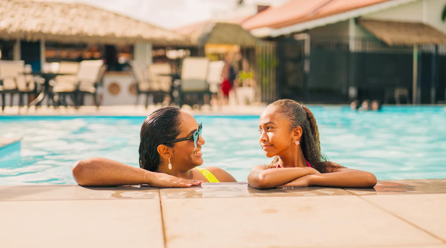 Two travelers relax by the luxurious pool at the Bambou Resort Martinique