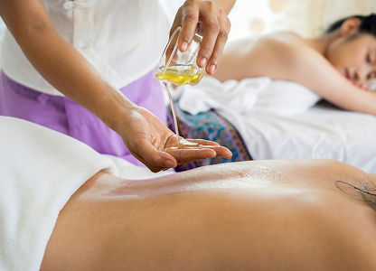 Thérapeute versant huile massage relaxant sur dos client spa luxe Martinique