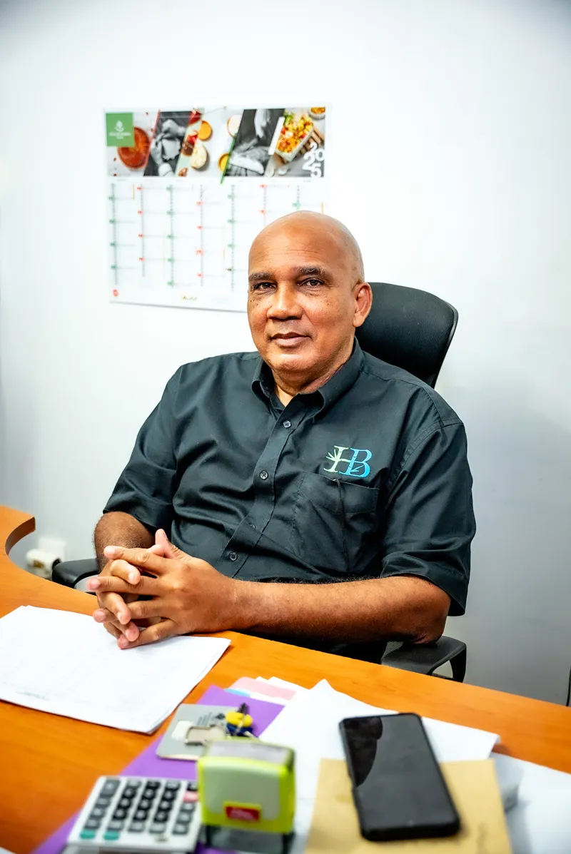Bambou Resort team member seated at desk wearing hotel logo embroidered shirt