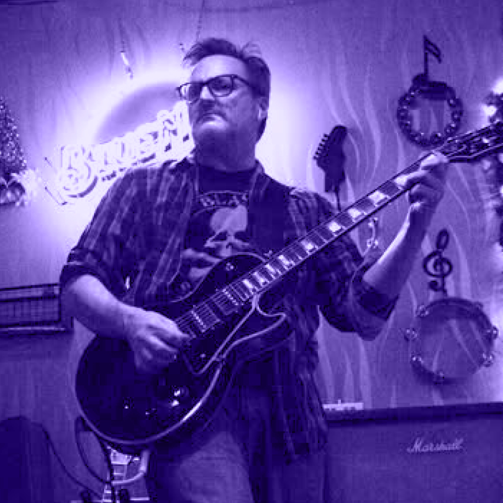 Jon on stage playing electric guitar