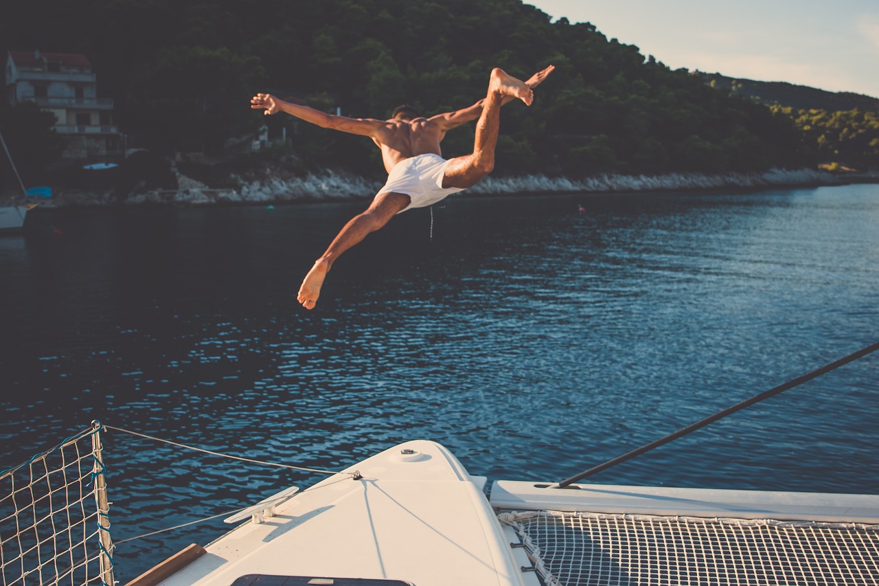 A man jumping from a Yacht Dock.
