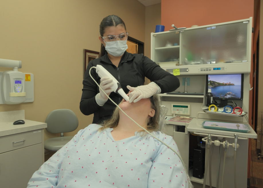 patient getting intraoral scans done by dental assistant