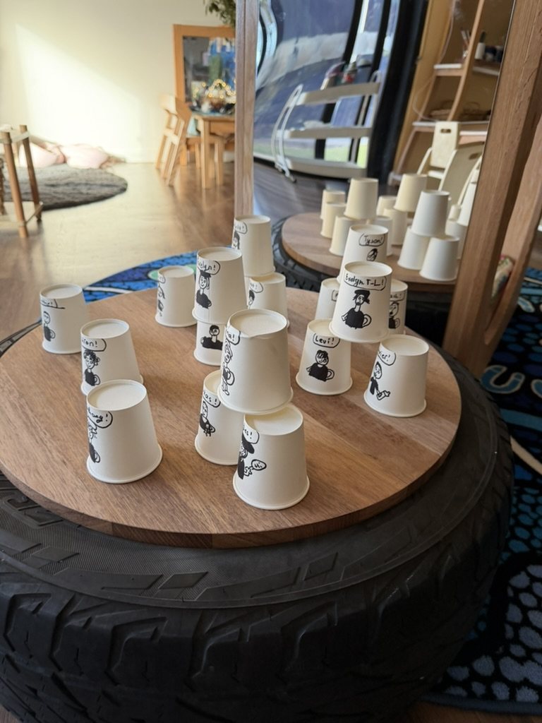 Paper cup self-portraits on a tyre table