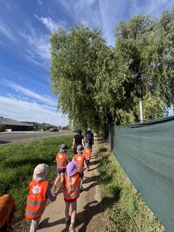 Children on a community walk in hi-vis vests