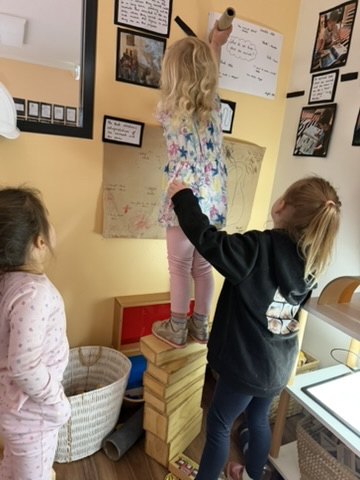 Children adding to their documentation wall