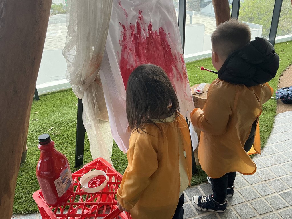 Children exploring fabric and colour outdoors