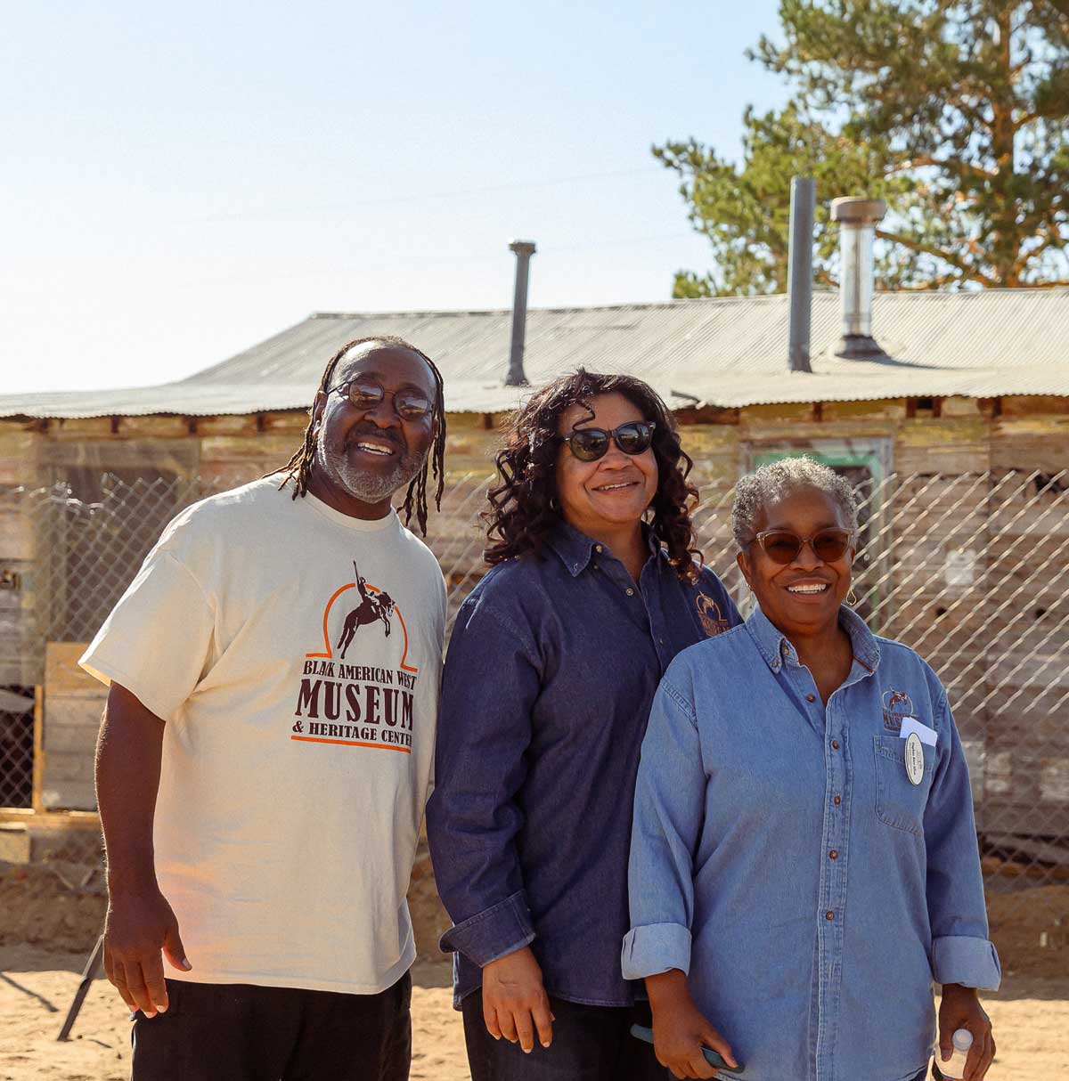 Three members of the board in front of the Dearfield house