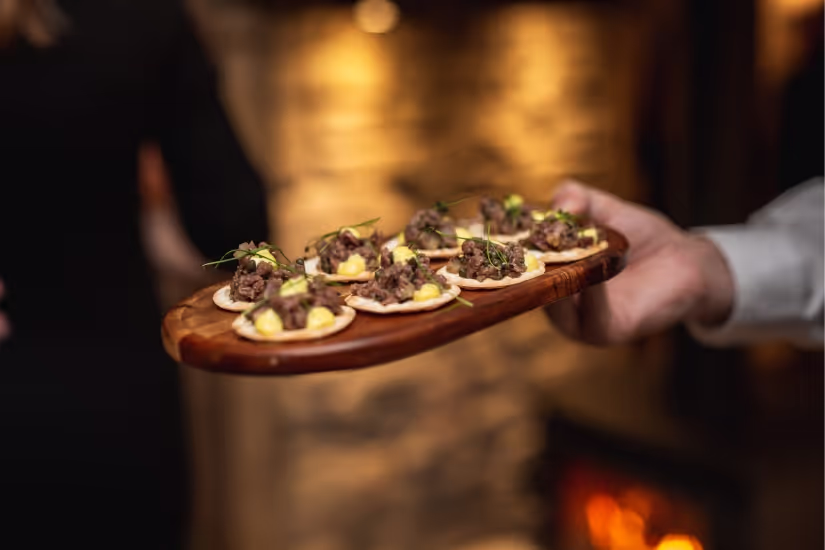 Close up shot of two people holding a pizza