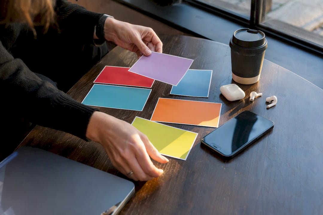 Hands organizing digital marketing campaign materials