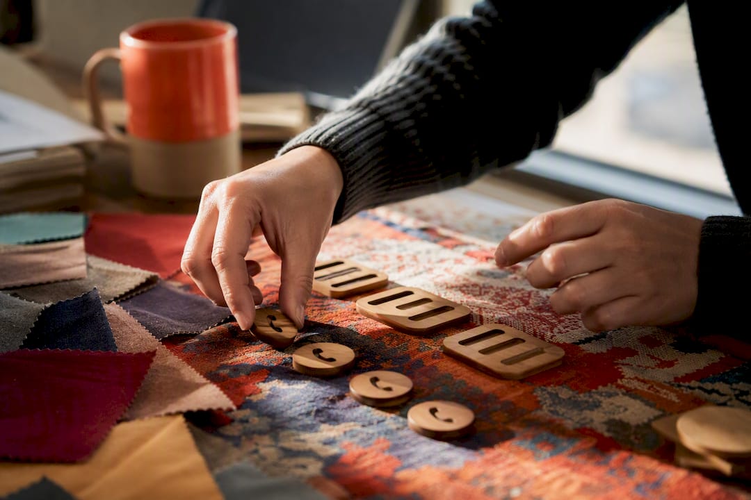 Hands placing ad extension elements on table