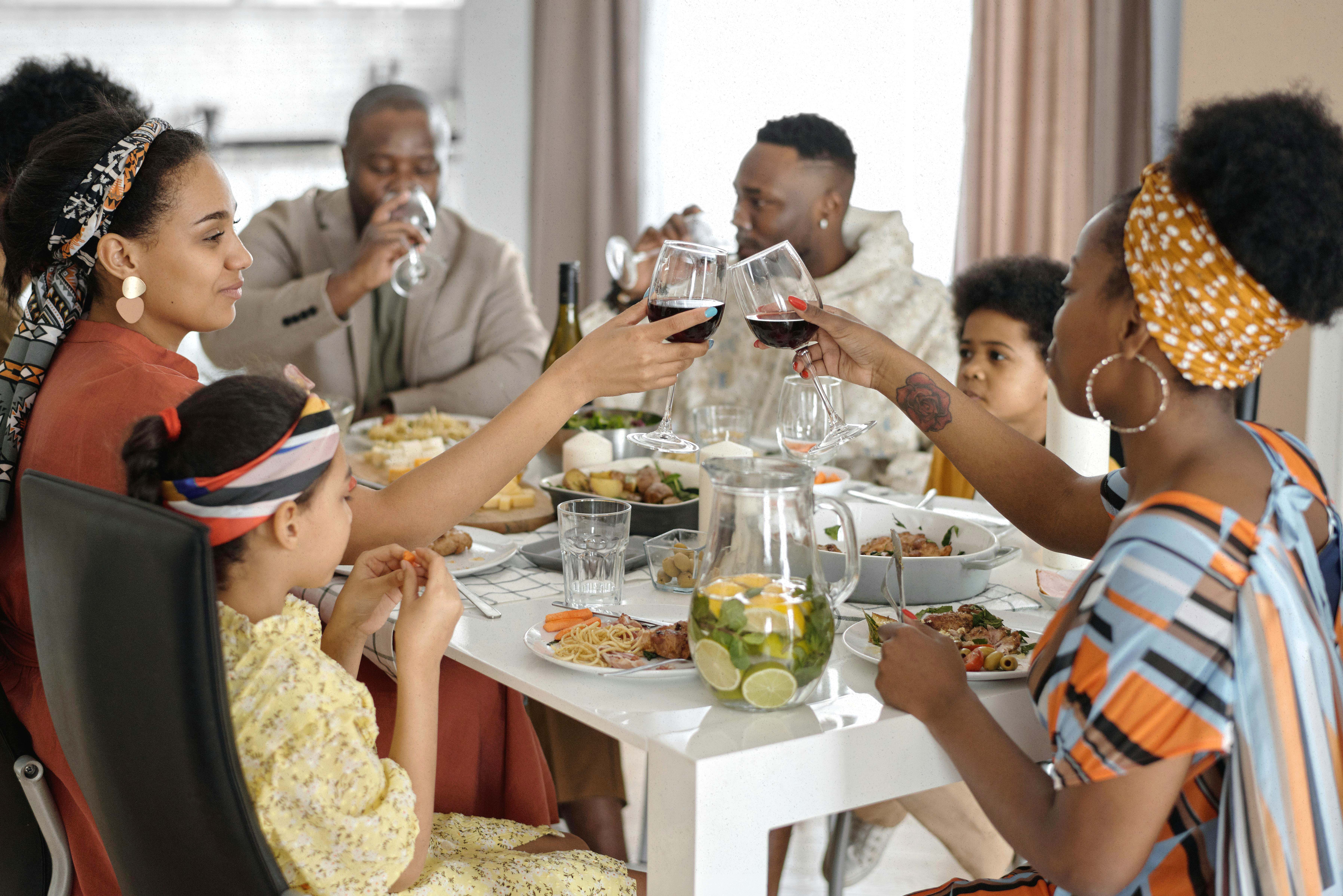 Smiling family enjoying dinner together in a warm home setting, symbolizing positive relationships and the importance of staying grounded when familiar family triggers emerge.
