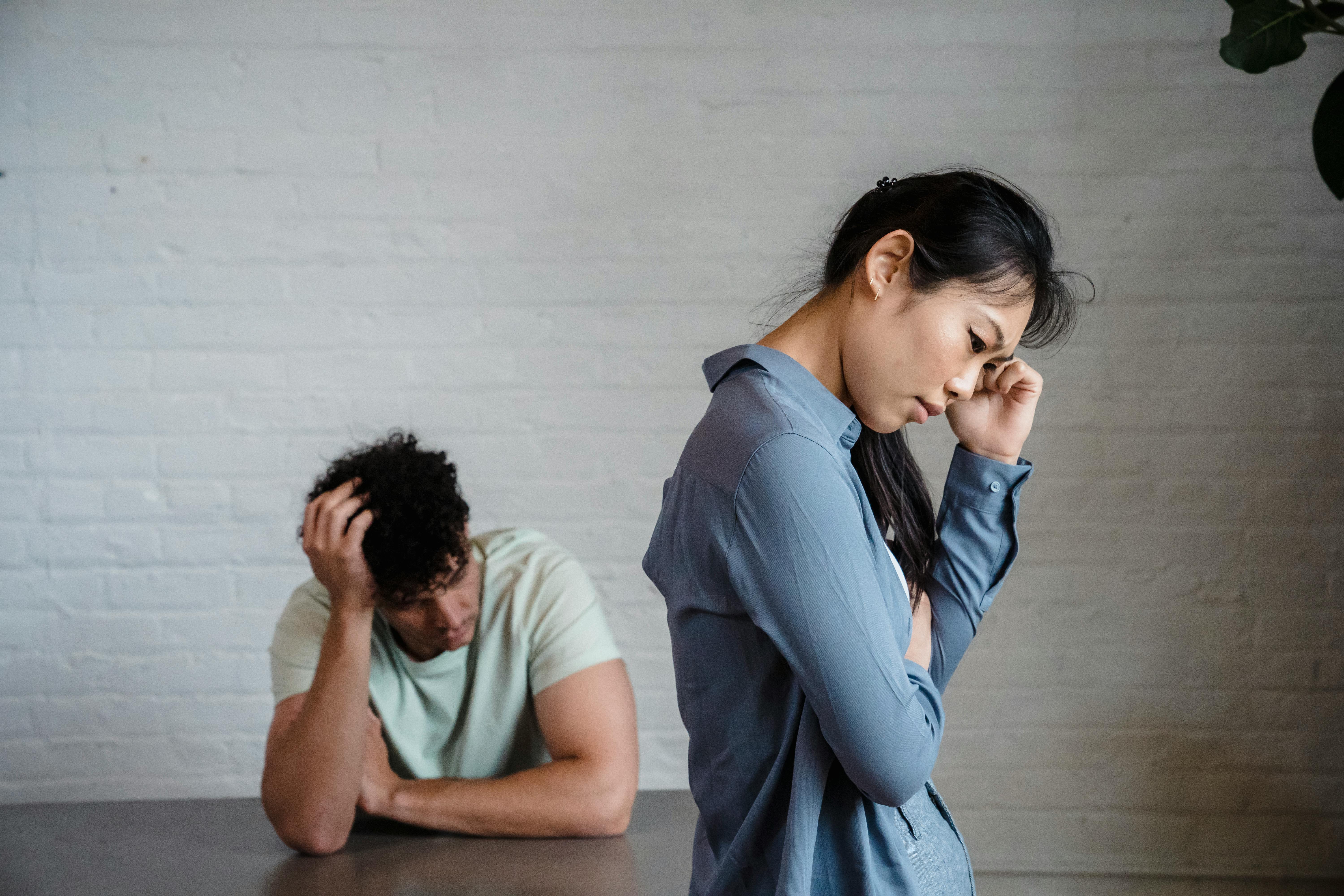 One partner turned away while the other sits distressed, illustrating emotional imbalance when one person wants connection without commitment.