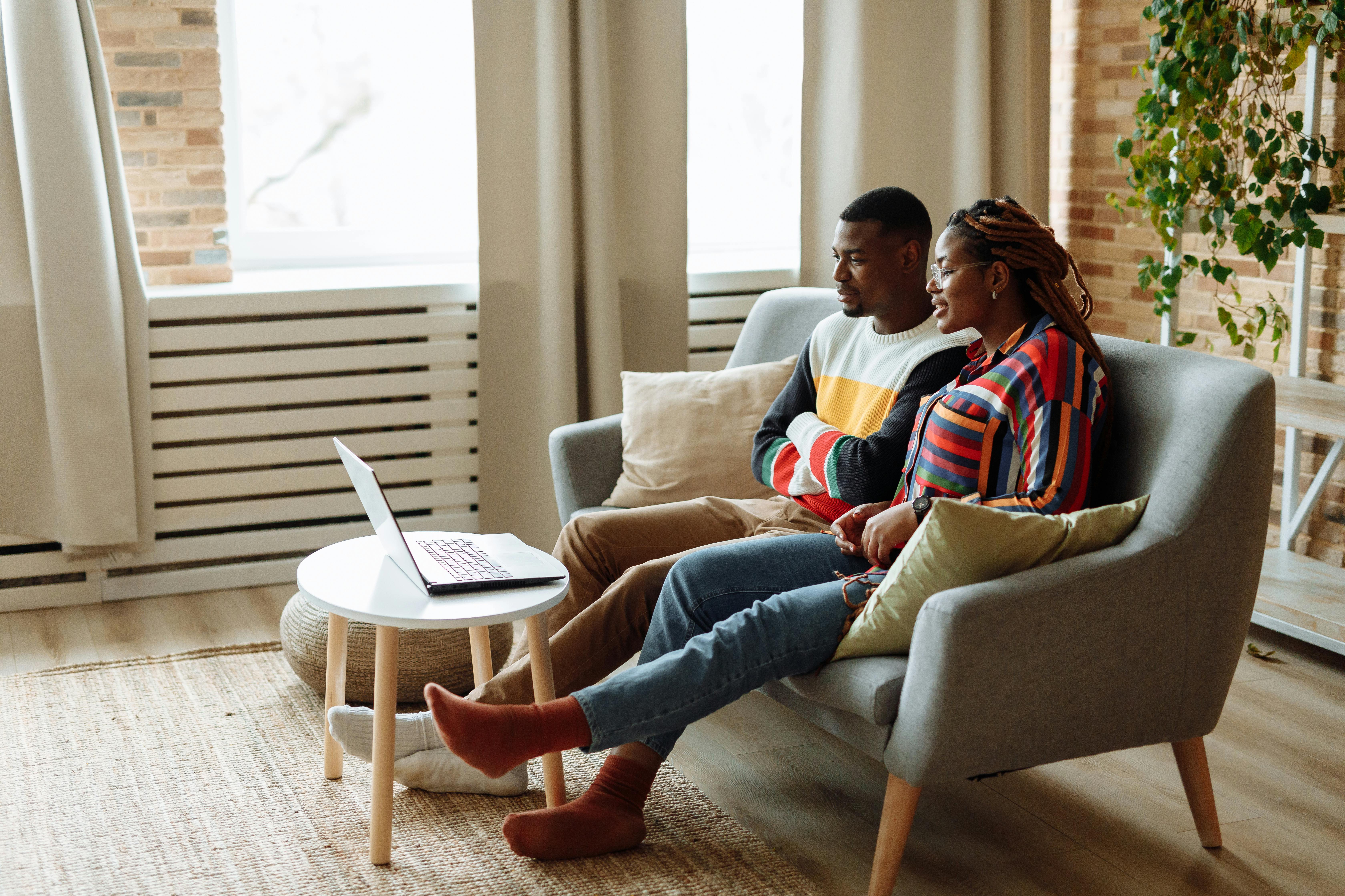 Couple sitting together at home in a virtual couples therapy session on a laptop, illustrating online couples therapy in California and Pasadena.
